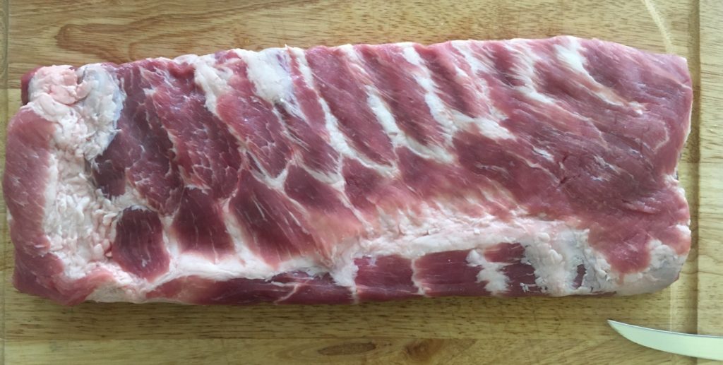 raw st louis ribs on a cutting board