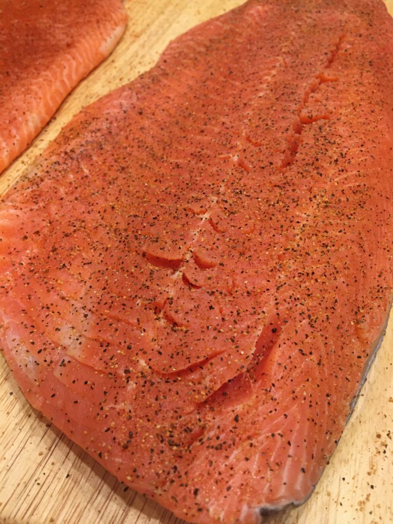 raw salmon filet seasoned with pepper